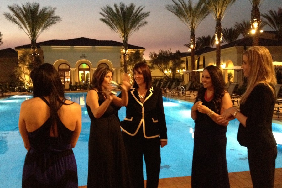 A group of women standing next to each other near a pool.