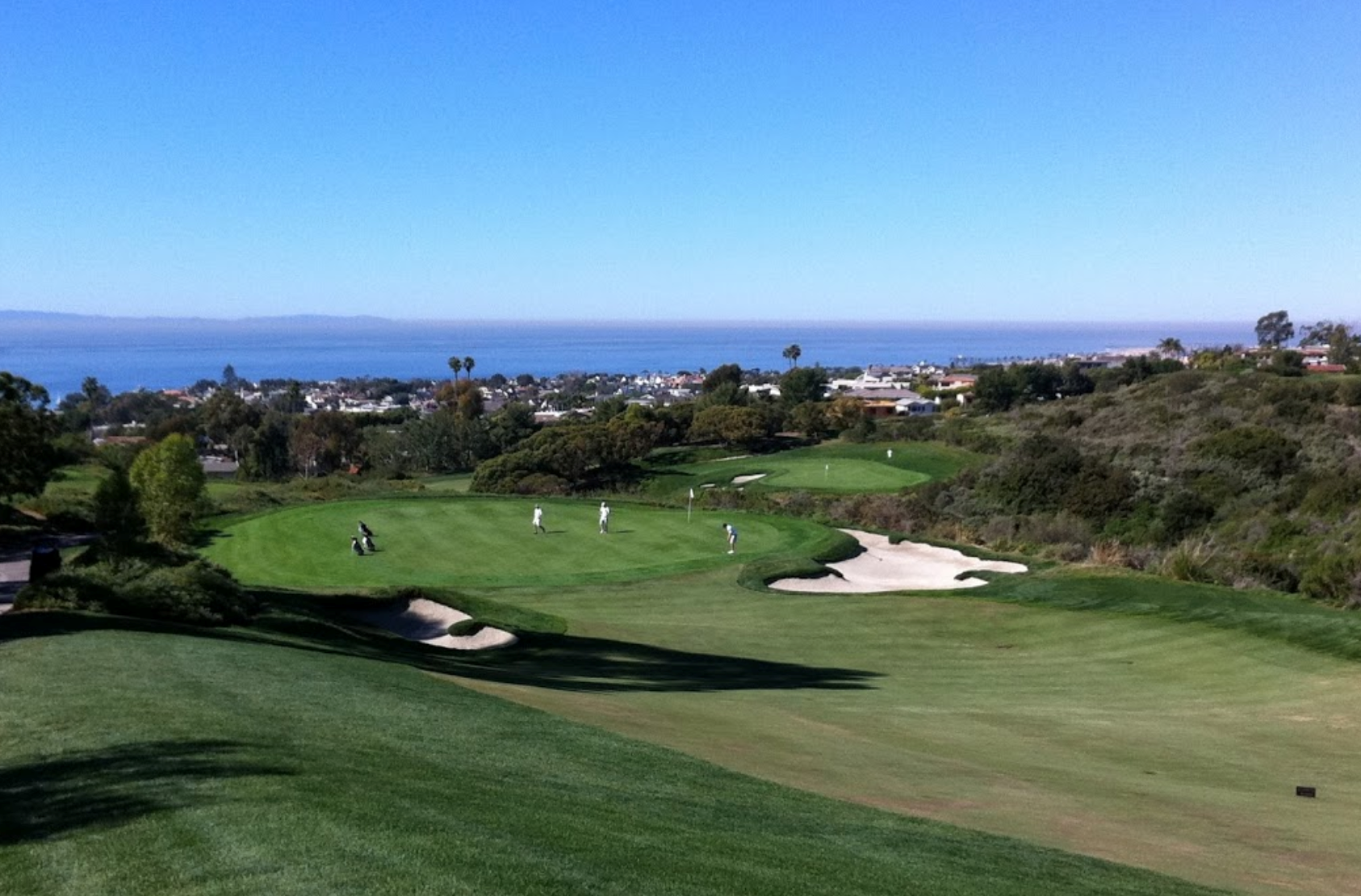 A view of people playing golf on the green.